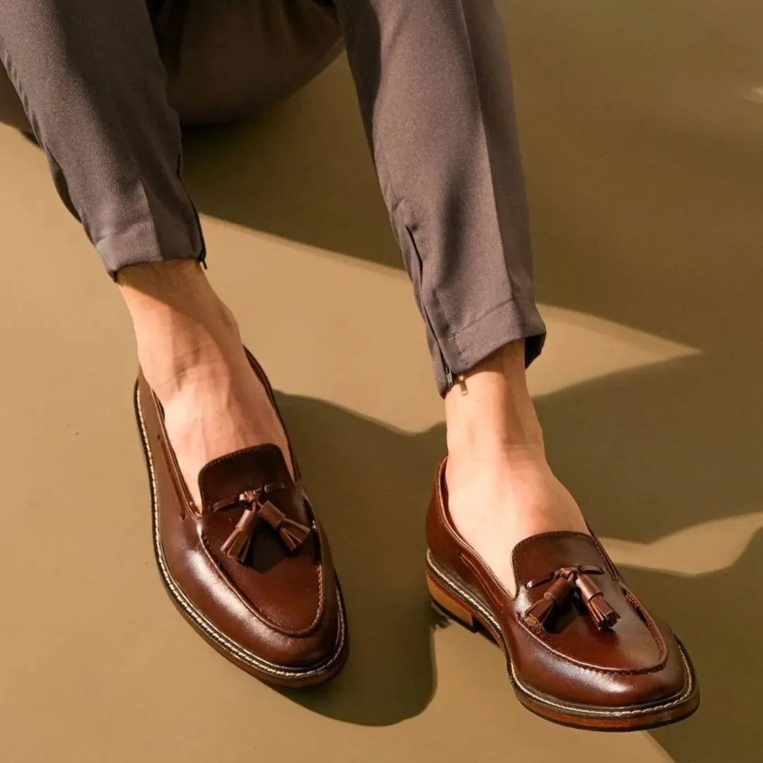 Walnut Brown loafers with tassels worn by a person on a beige background
#color_walnut