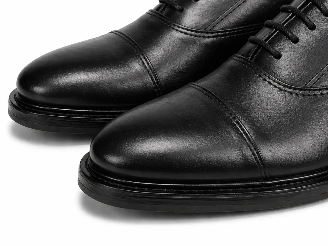 Pair of black leather dress shoes on a white background
#color_black
