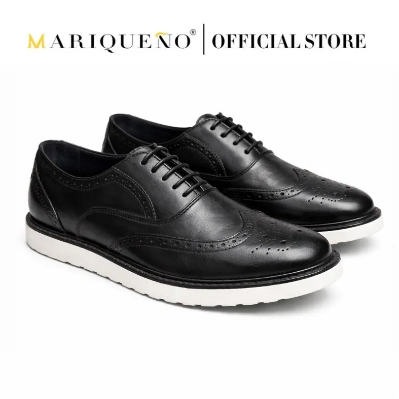 Black wingtip leather shoes with white rubber soles on a white background, featuring the Mariqueno brand.
#color_black