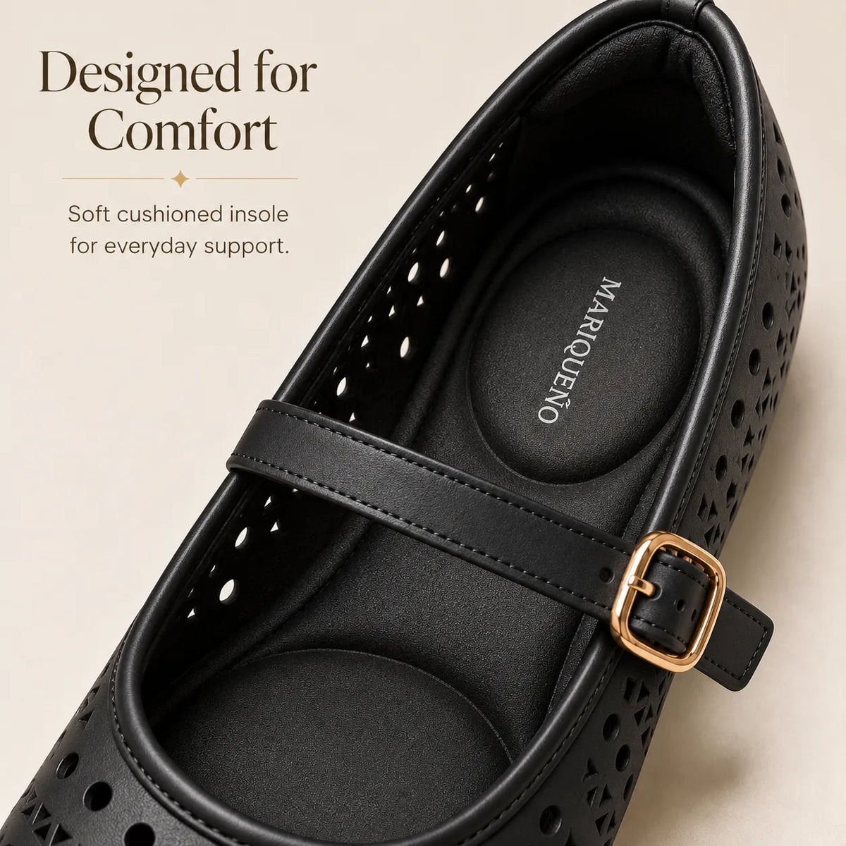 A close-up of a black perforated shoe with geometric cutouts and a tan outsole, shown on a white background.
#color_black