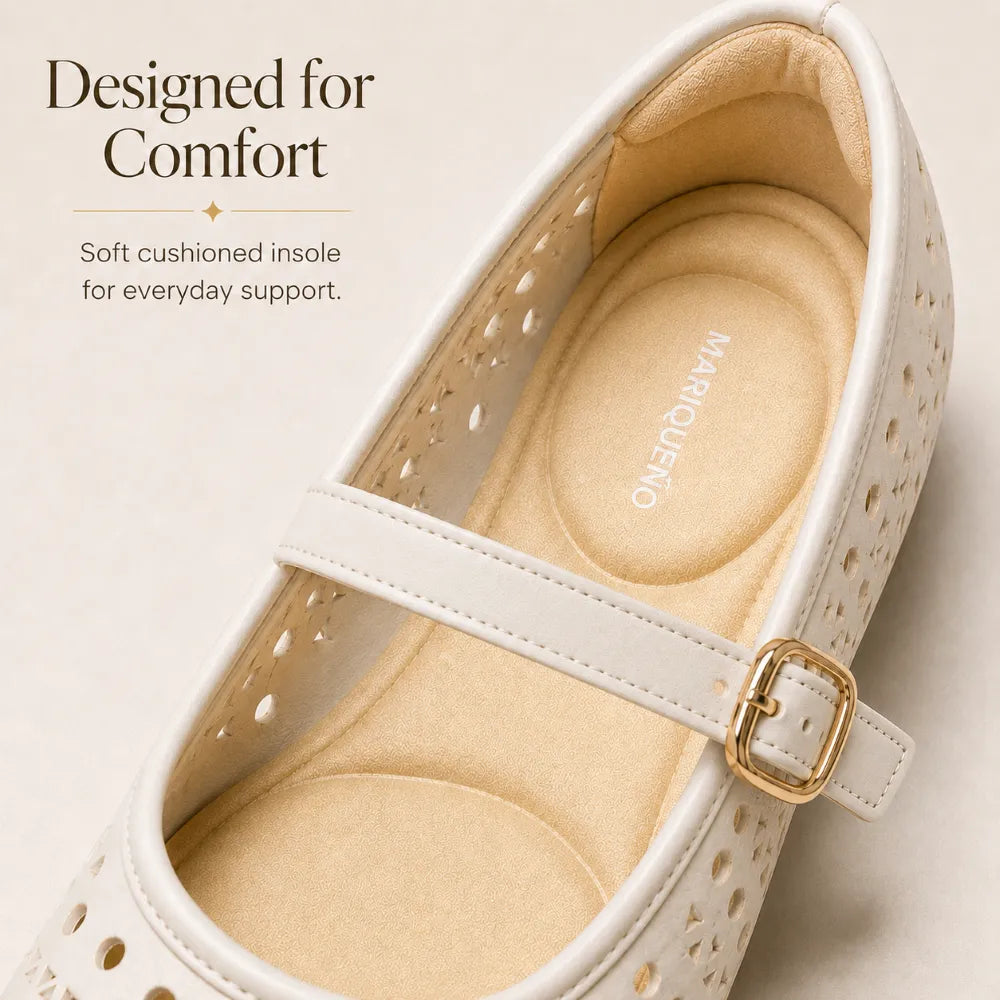 A close-up of a white perforated Mary Jane shoe with geometric cutouts and a tan sole, shown on a white background.
#color_white