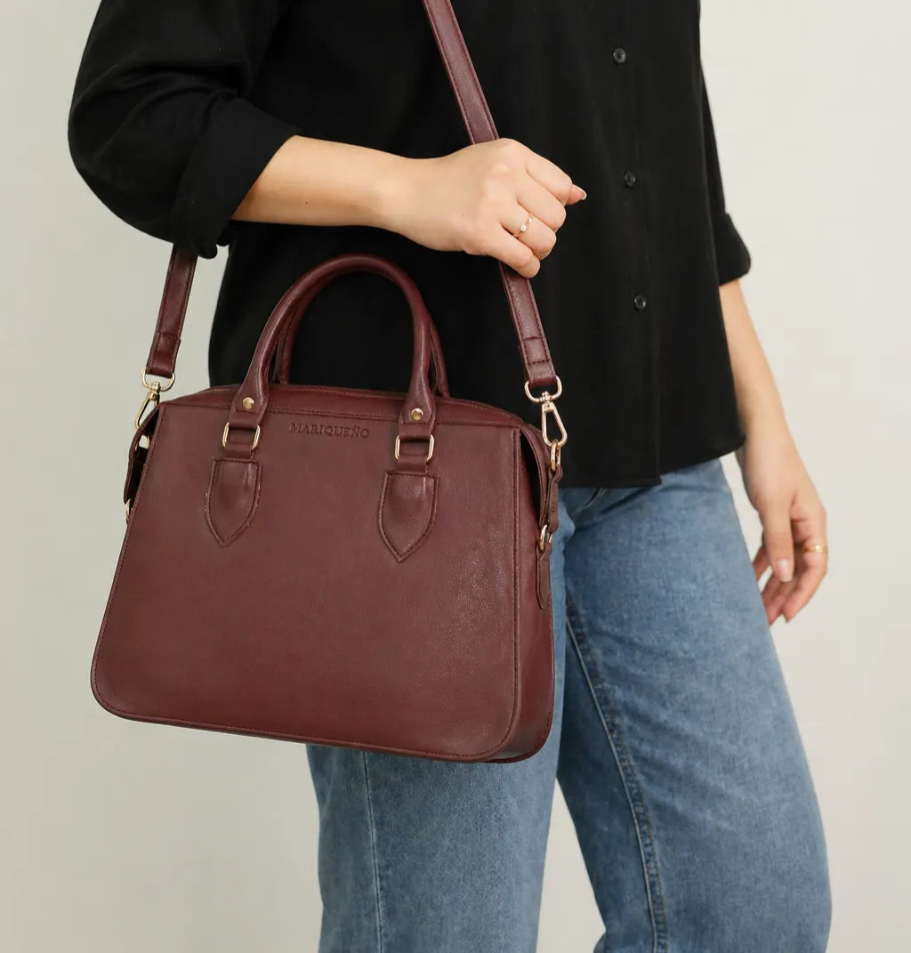 Person holding a brown leather handbag with a plain background
#color_choco brown