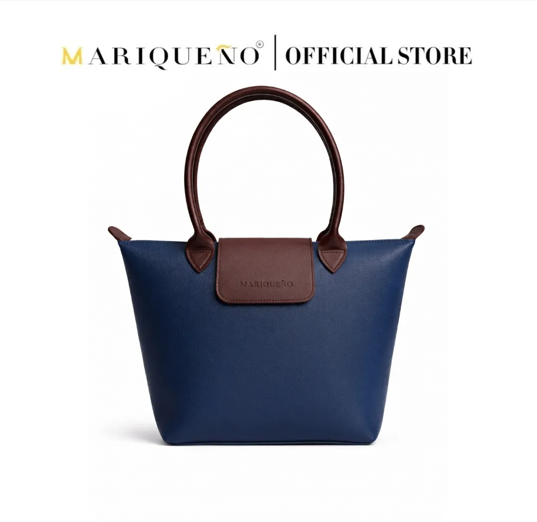 Blue handbag with brown handle and trim on a white background, featuring Mariqueno branding.
#color_blue