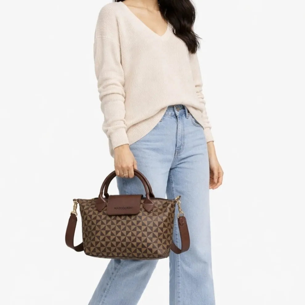 Person holding a brown patterned handbag with a visible brand logo.
#color_choco brown geo