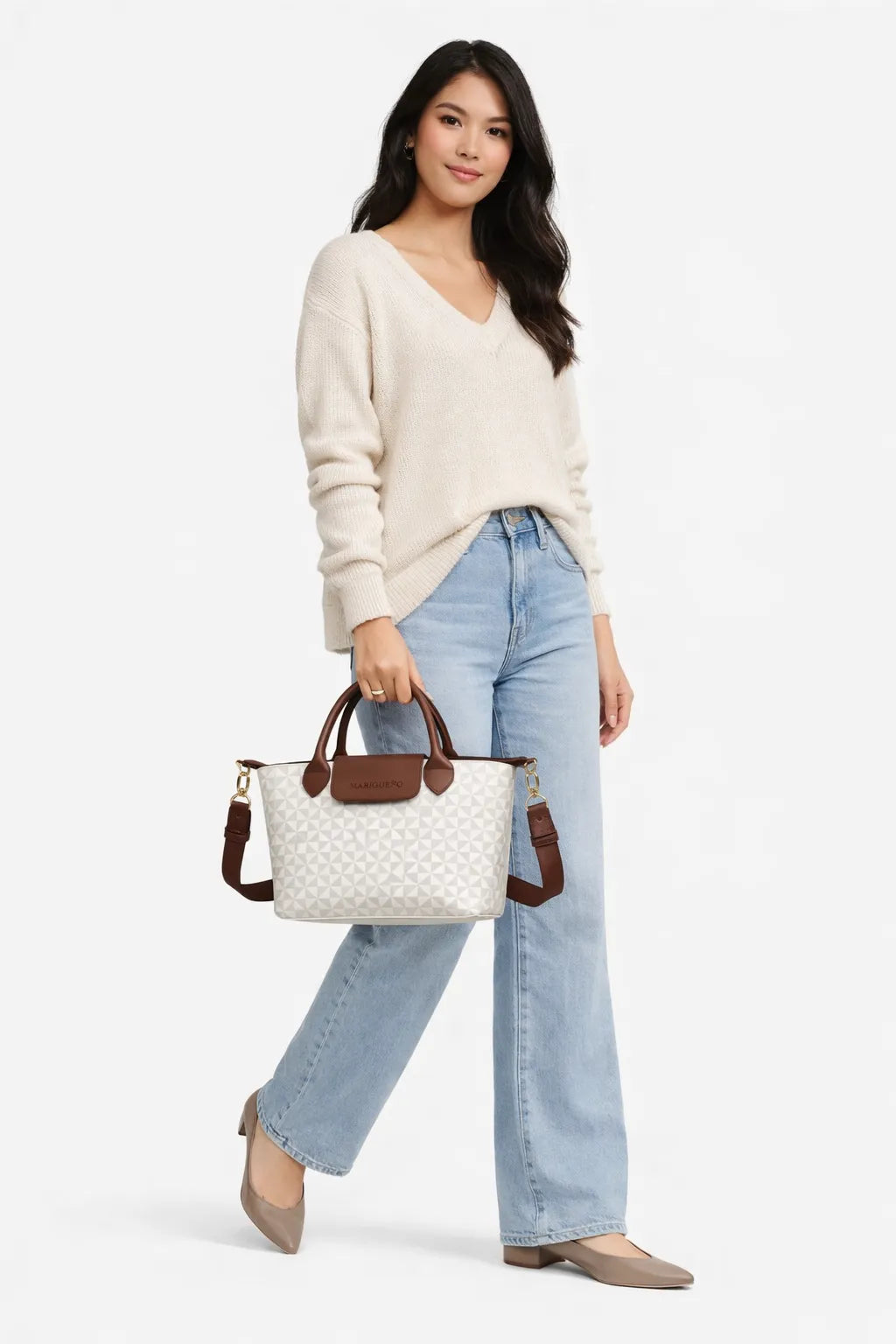 Woman holding a white geo patterned handbag with brown handles against a white background
#color_sandstone geo