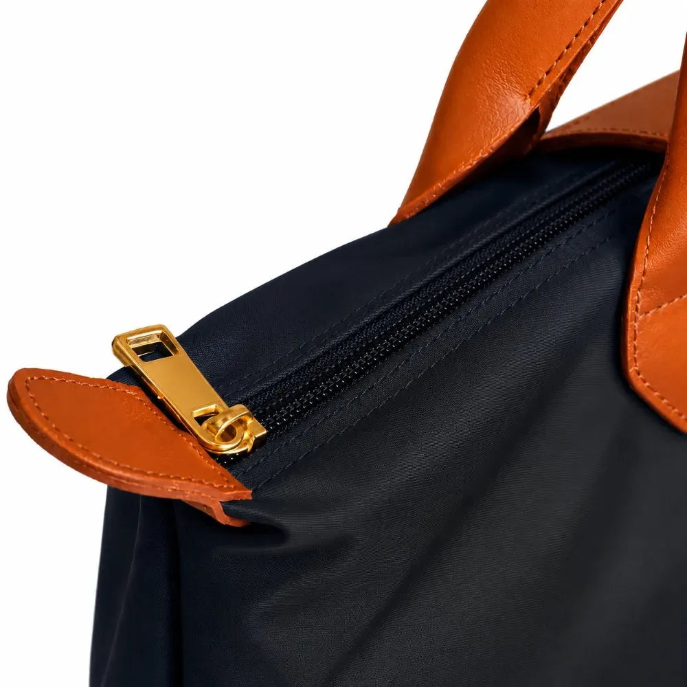 Black bag with brown leather handles and zipper on a white background
#color_black and tan