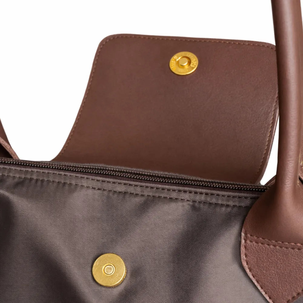 Close-up of a brown handbag with gold buttons on a white background
#color_choco brown