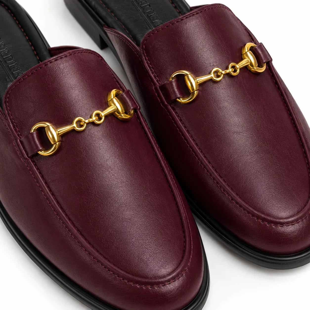 Pair of burgundy loafers with gold horsebit details on a white background
#color_oxblood
