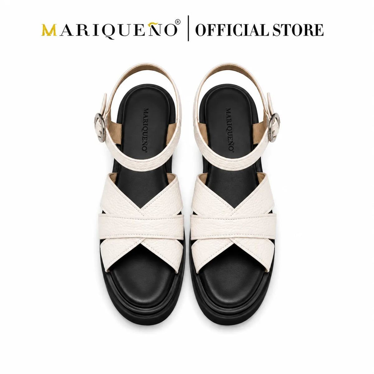 A pair of Mariqueno brand women's flat sandals with cream-colored textured straps, a black sole, and silver buckle details, shown against a plain white background with the 'Mariqueno | Official Store' logo at the top.
#color_white