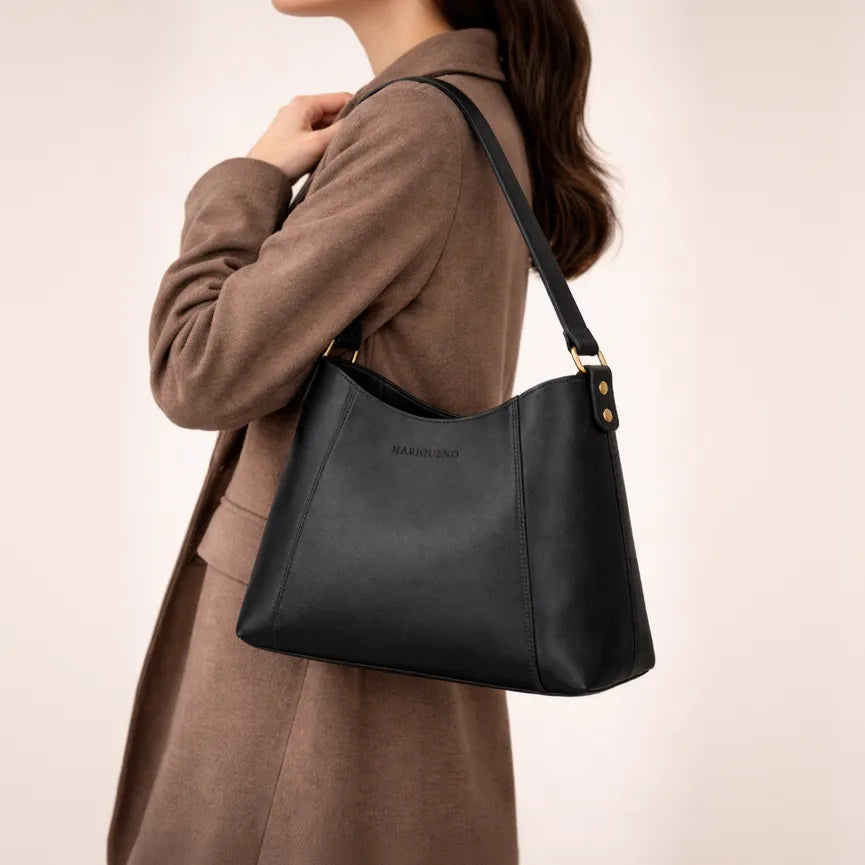 Person wearing a brown coat with a black handbag on a beige background
#color_black