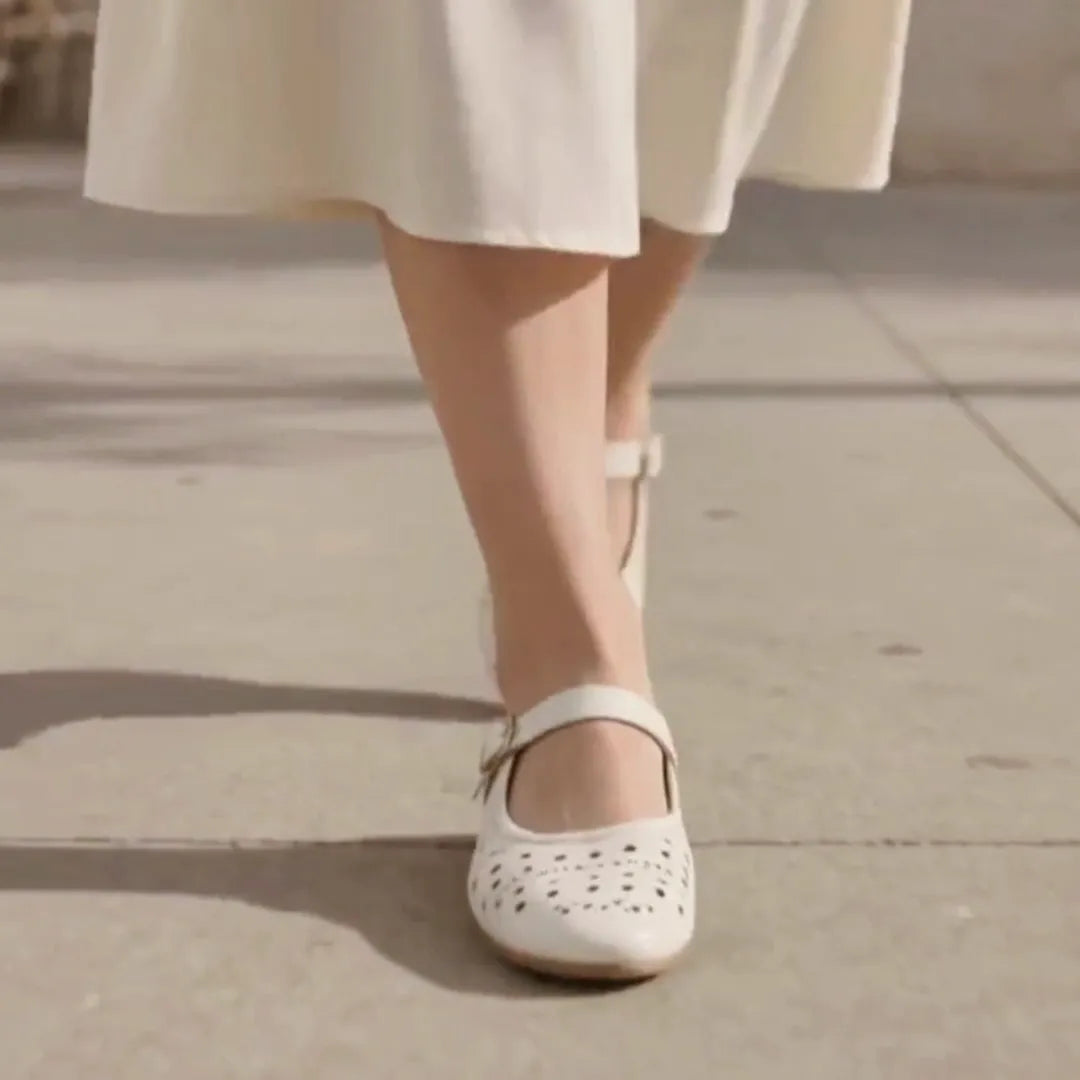 A woman wearing white mary jane flats
#color_white