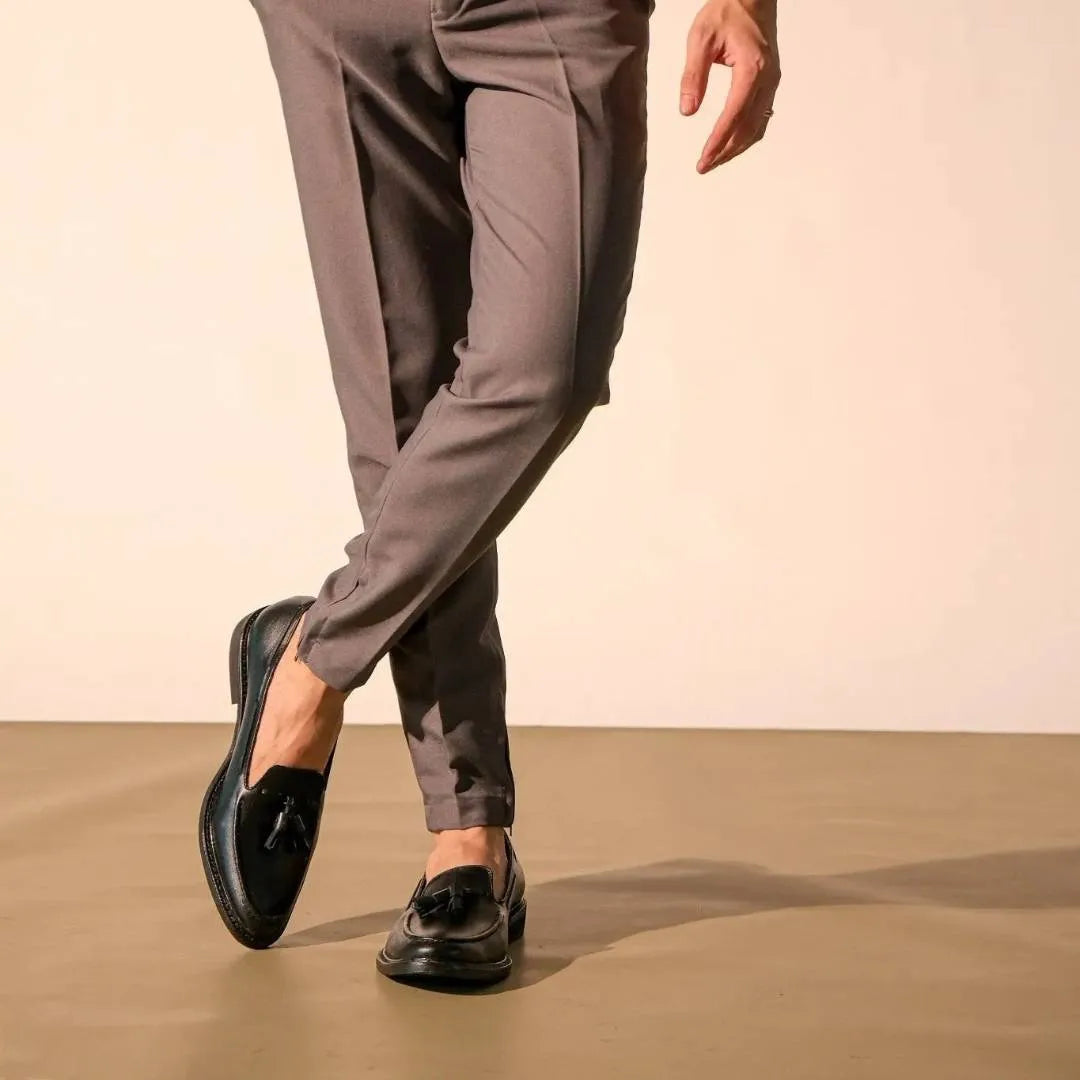 Person wearing gray pants and black shoes on a beige background
#color_black