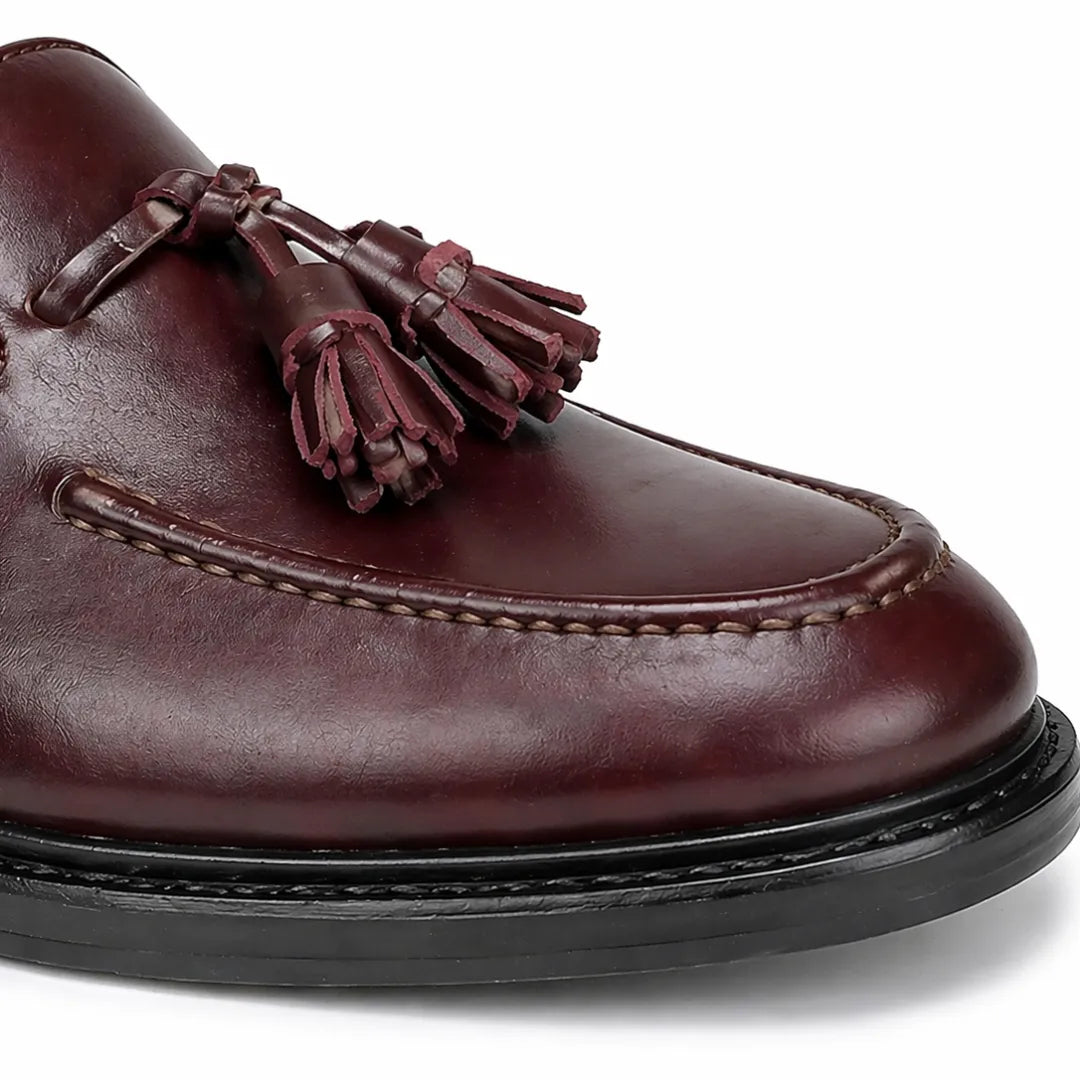 Brown leather loafer with tassels on a white background
#color_oxblood