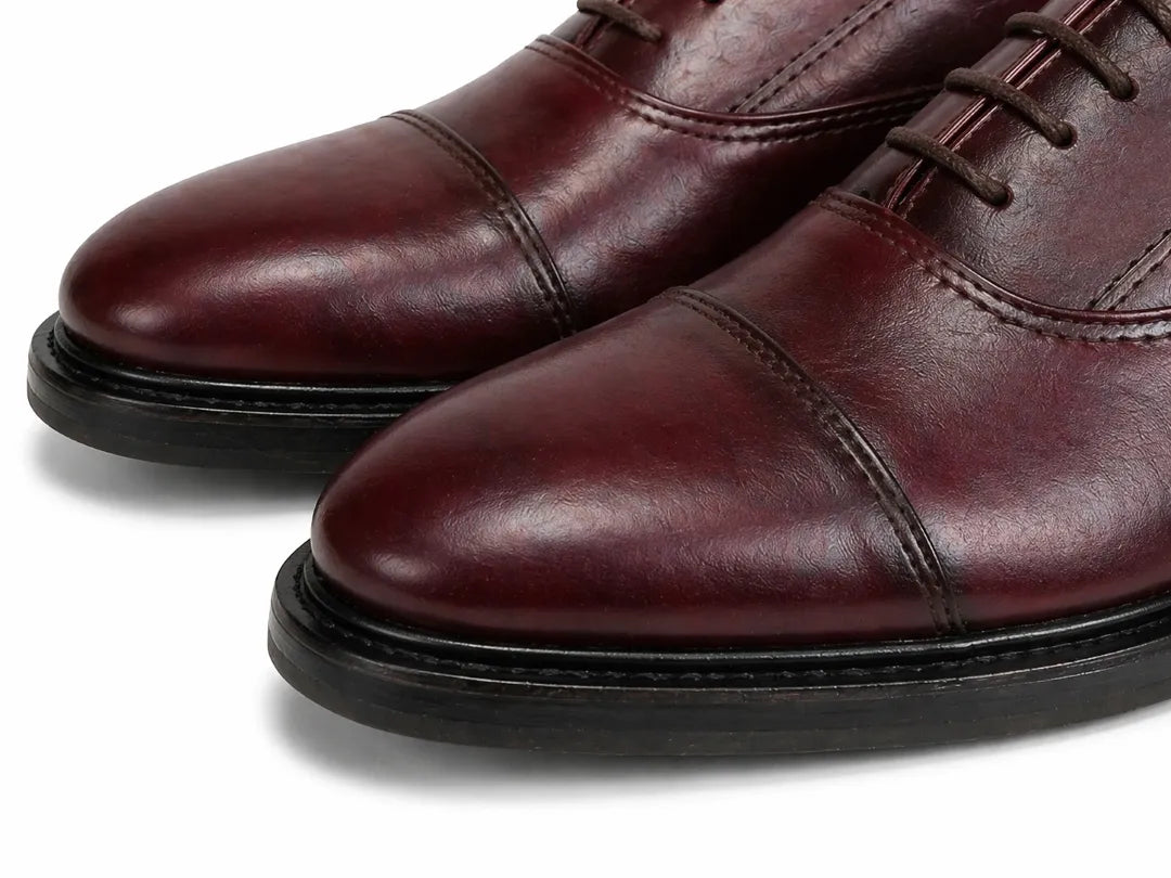 Pair of brown leather dress shoes on a white background
#color_oxblood