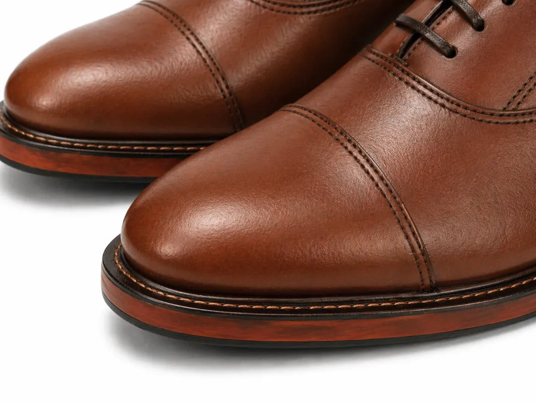 Close-up of brown leather dress shoes on a white background
#color_walnut