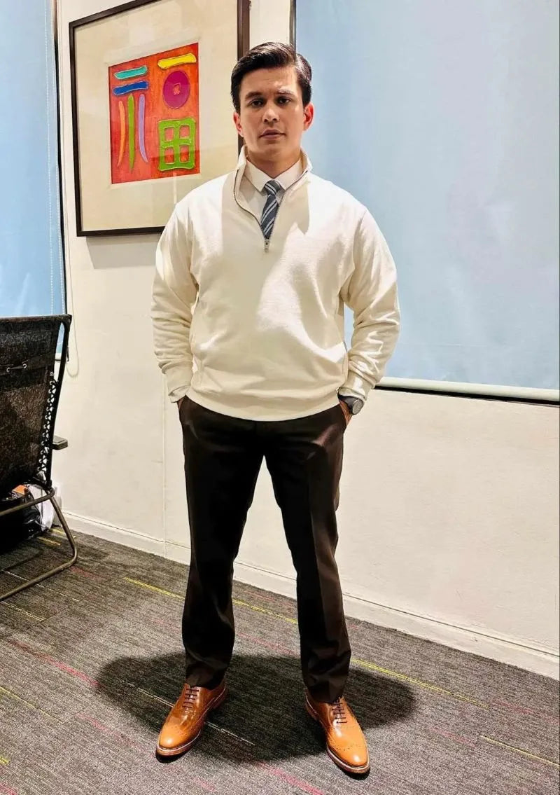 Tom Rodriguez tan brown wingtip oxford shoes in an indoor setting.
#color_tan