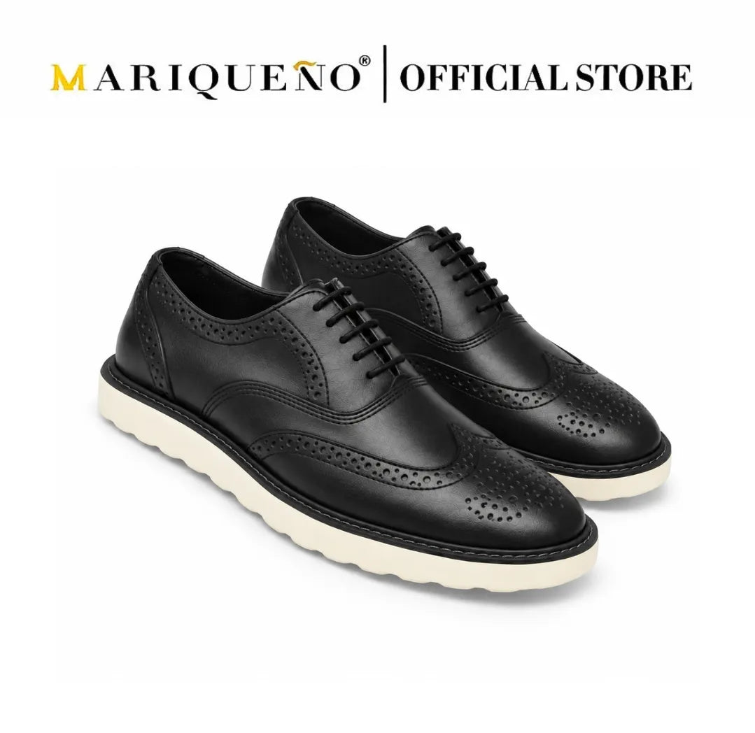 Black wingtip leather shoes with white rubber soles on a white background, featuring the Mariqueno brand.
#color_black