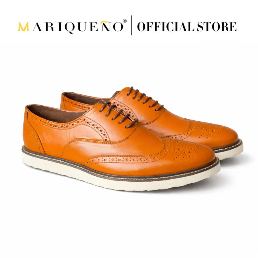 Tan brown leather shoes with white rubber soles on a light gray background, featuring the Mariqueno brand.
#color_tan