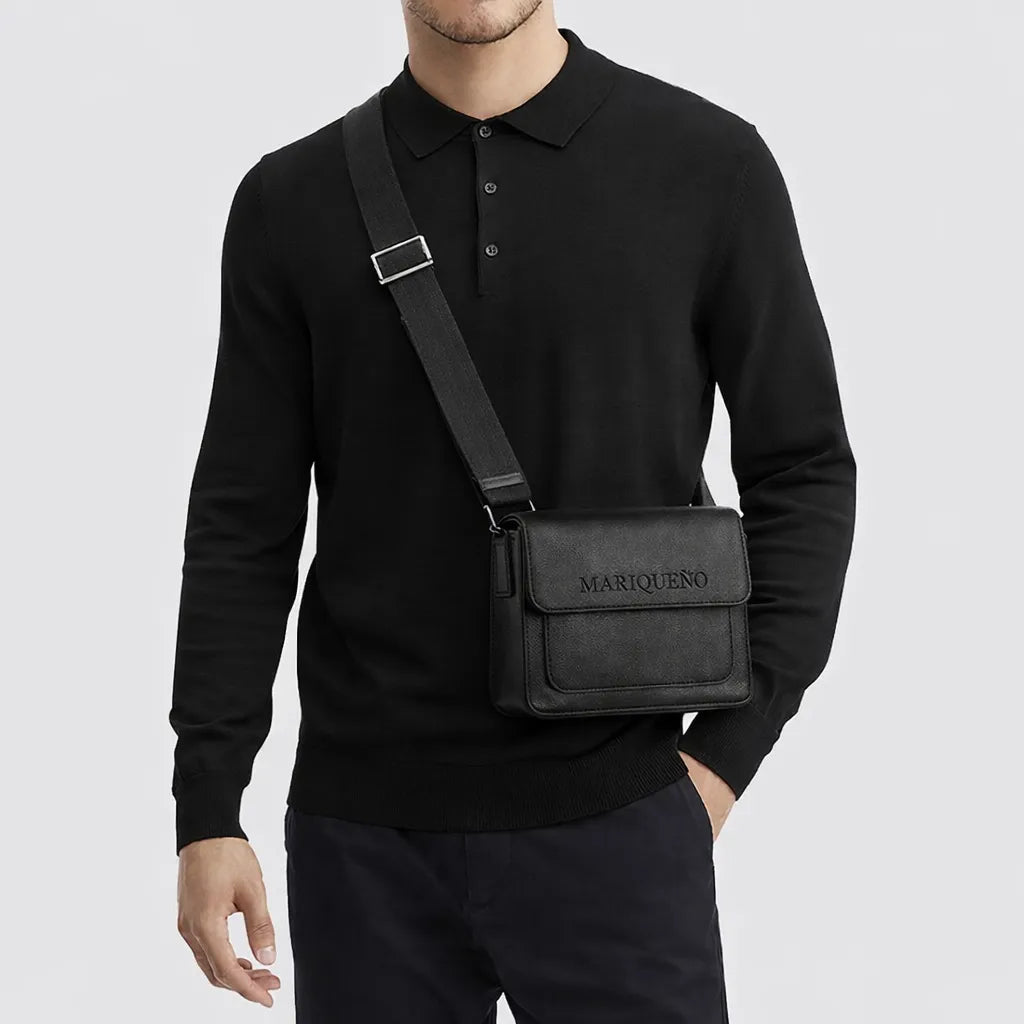 Person wearing a black sweater with a black top handle bag labeled 'MARIQUENO' on a light gray background
#color_black