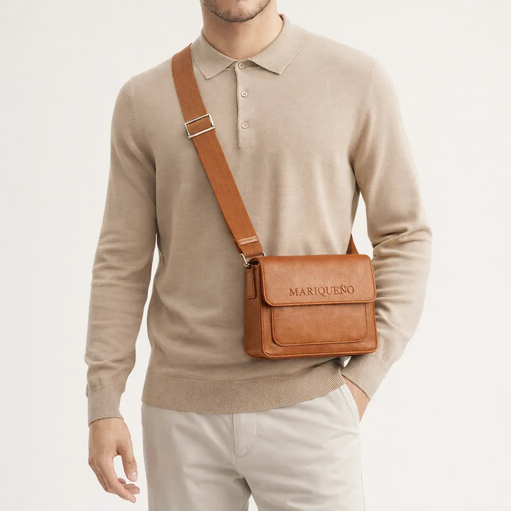 Man wearing a tan brown leather top handle bag with 'MARIQUENO' branding on a light background
#color_tan