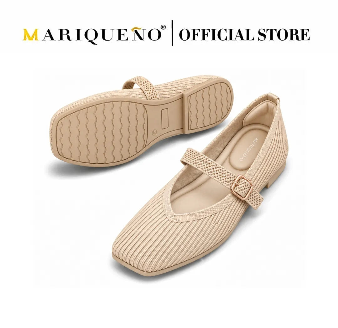 A pair of Mariqueno flat shoes in a light beige textured fabric, featuring a Mary Jane strap with a small metallic rose gold buckle. One shoe is shown from the side profile, and the other is shown from the sole view, set against a plain white background with the Mariqueno brand logo at the top.
#color_beige