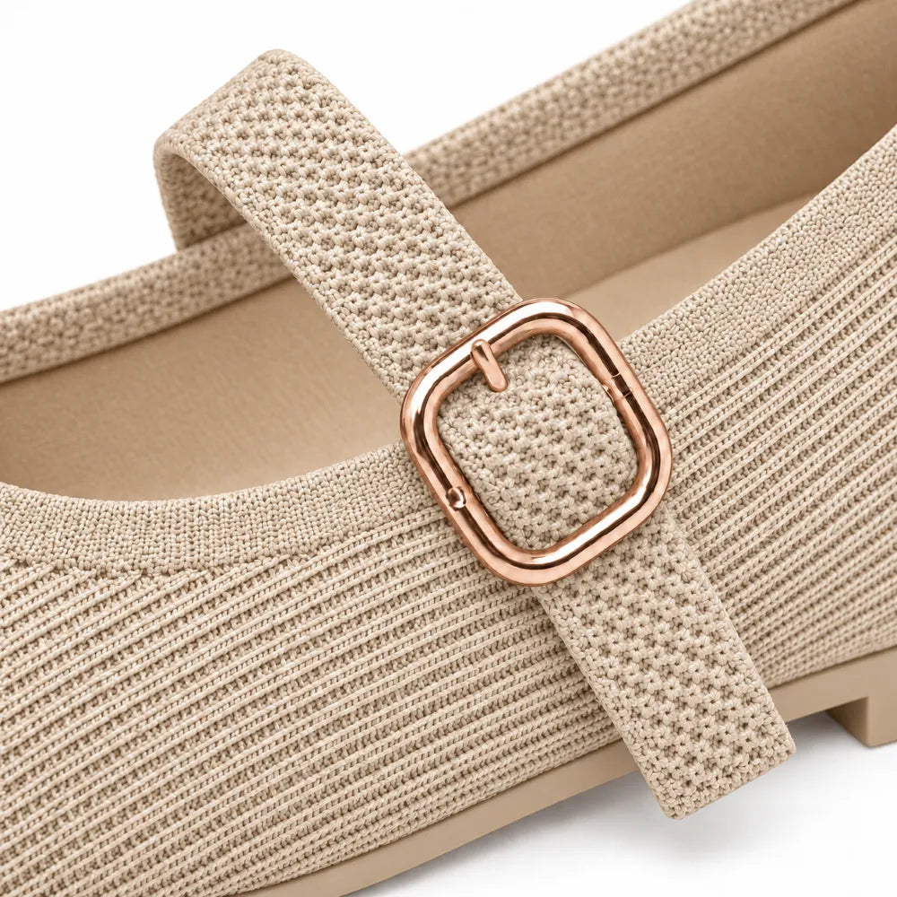 Close-up of a beige knit Mary Jane shoe with a textured strap and a rose gold square buckle, shown on a white background.
#color_beige