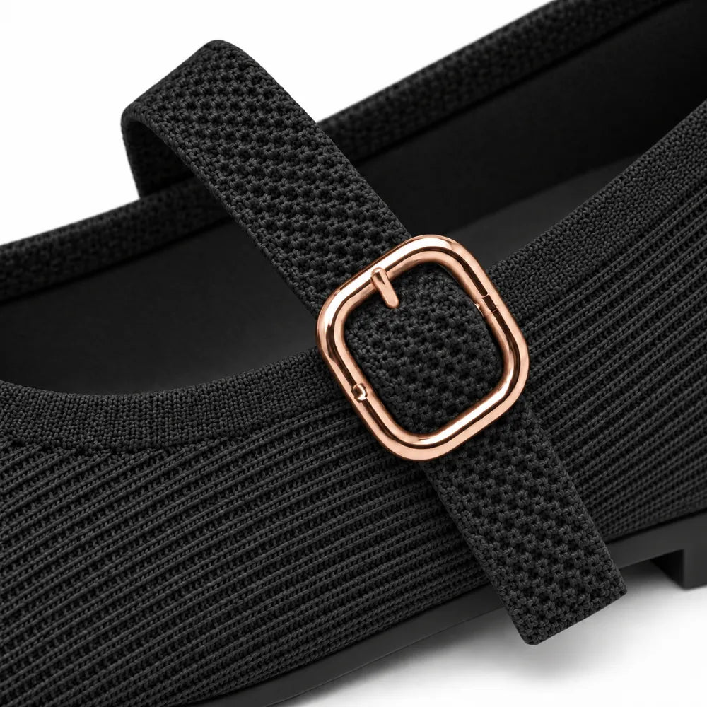 Close-up of a black knit Mary Jane shoe with a square rose gold buckle on a white background.
#color_black