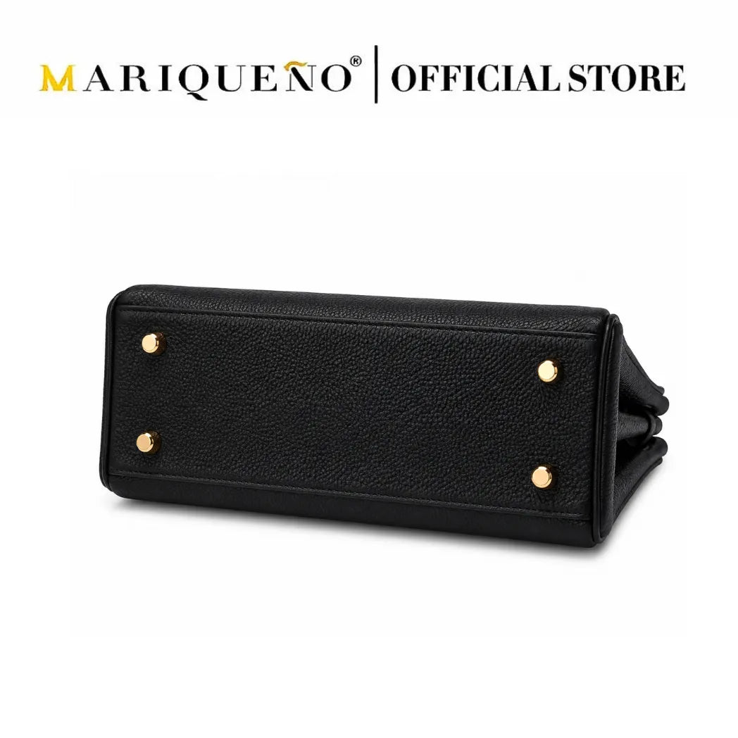 A black pebbled leather handbag shown from the bottom, featuring four gold-tone metal studs on the base, set against a plain white background with 'MARIQUEÑO | OFFICIAL STORE' text at the top.
#color_black