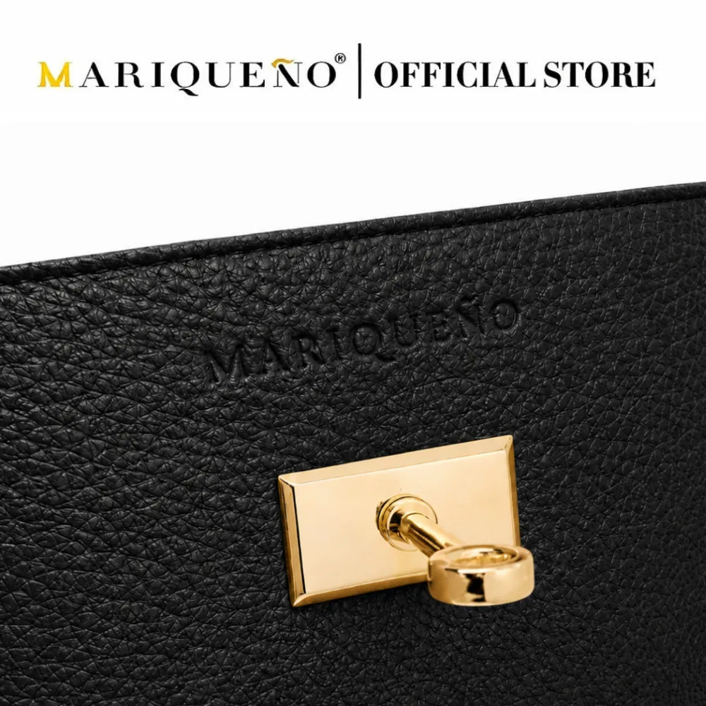 Close-up of a black textured leather hand bag with an embossed MARIQUEÑO logo and a polished gold-tone rectangular clasp, shown against a white background with the MARIQUEÑO | OFFICIAL STORE text at the top.
#color_black