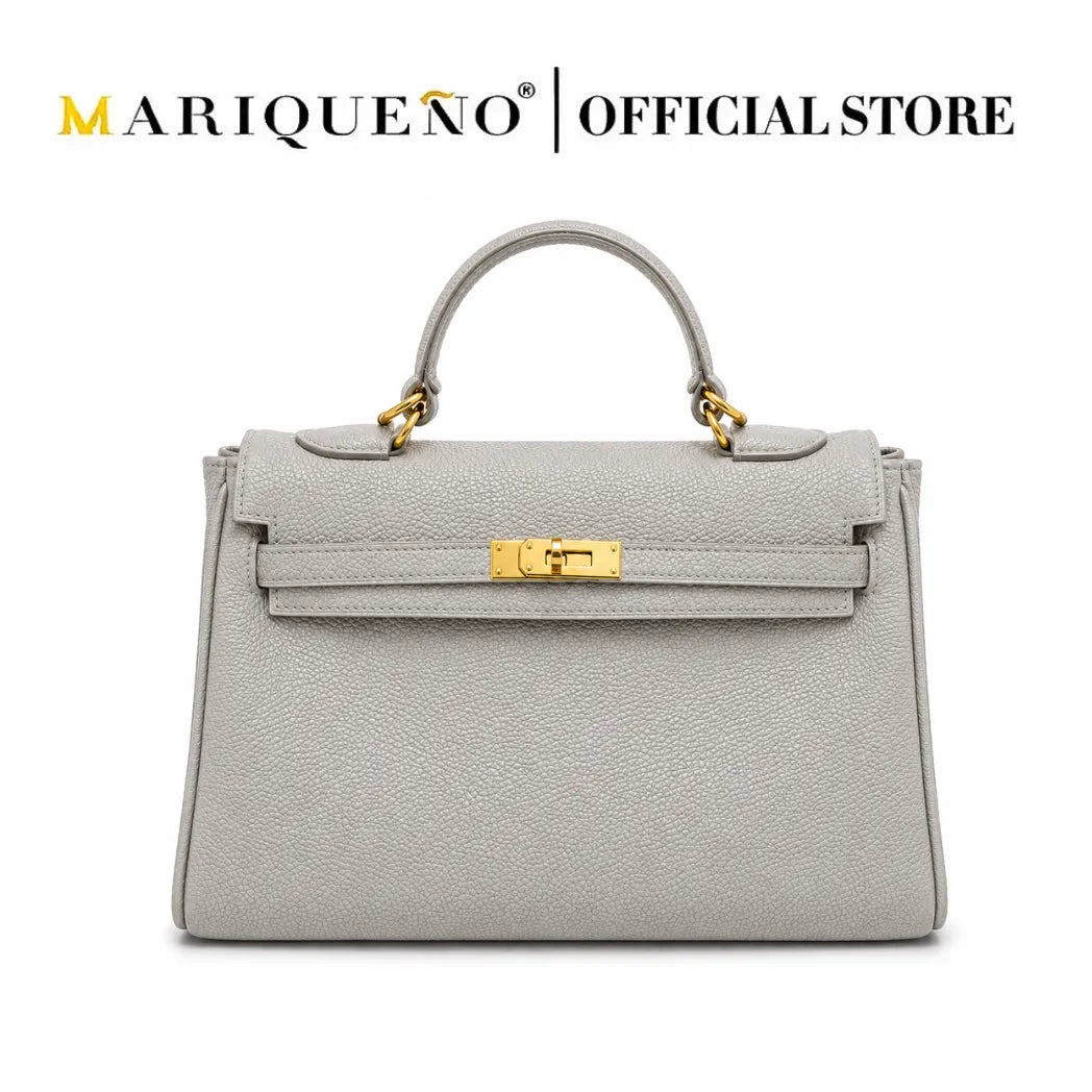 A light gray pebbled leather handbag with a top handle and gold-tone hardware, shown on a plain white background. The text 'MARIQUEÑO | OFFICIAL STORE' appears at the top.
#color_gray
