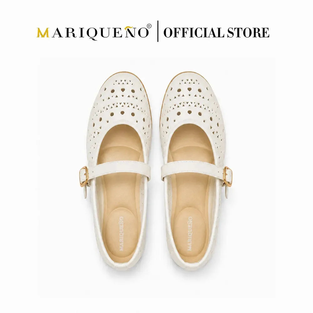 A pair of off-white Mary Jane shoes with perforated detailing on the toe and a gold buckle strap, shown from a top-down view on a white background with 'MARIQUENO | OFFICIAL STORE' text at the top.
#color_white