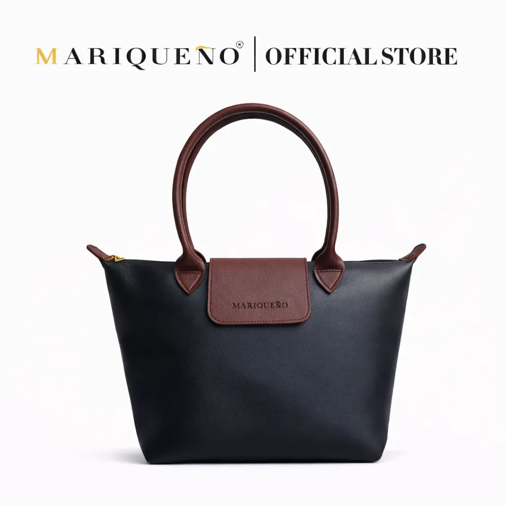 Black handbag with brown handle and patch on a white background, featuring Mariqueno branding.
#color_black