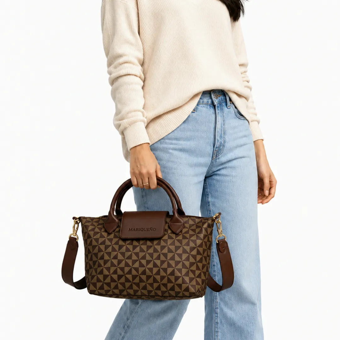 Person holding a brown patterned handbag with a visible brand logo.
#color_choco brown geo