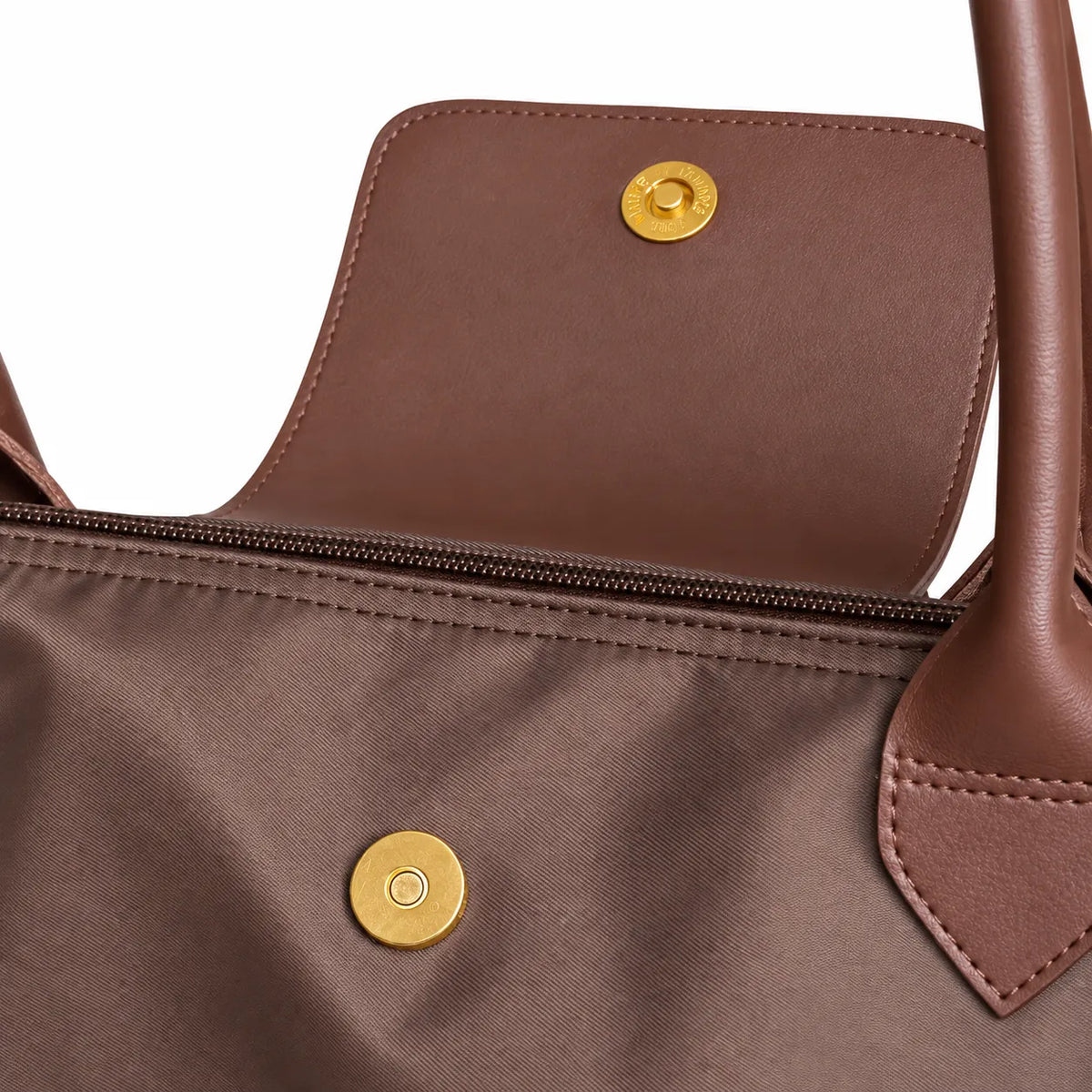 Close-up of a brown handbag with gold buttons on a white background
#color_choco brown