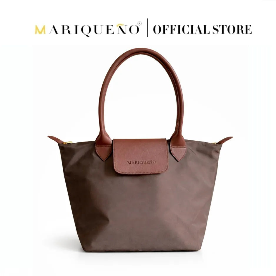 Brown handbag with leather handles and trim on a white background, featuring the Mariqueño brand.

#color_choco brown