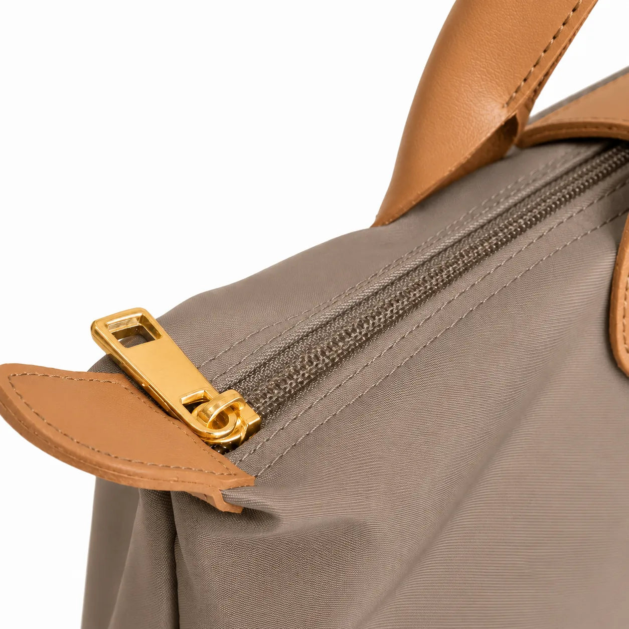 Close-up of a taupe bag with orange handles and zipper on a white background
#color_taupe