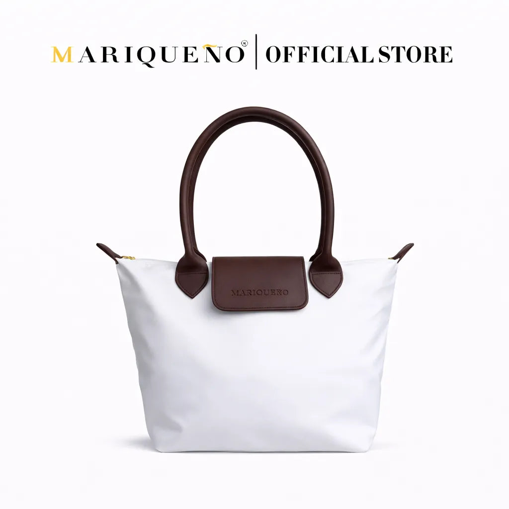 White handbag with brown handles and accents on a white background, featuring the Mariqueno brand.
#color_white