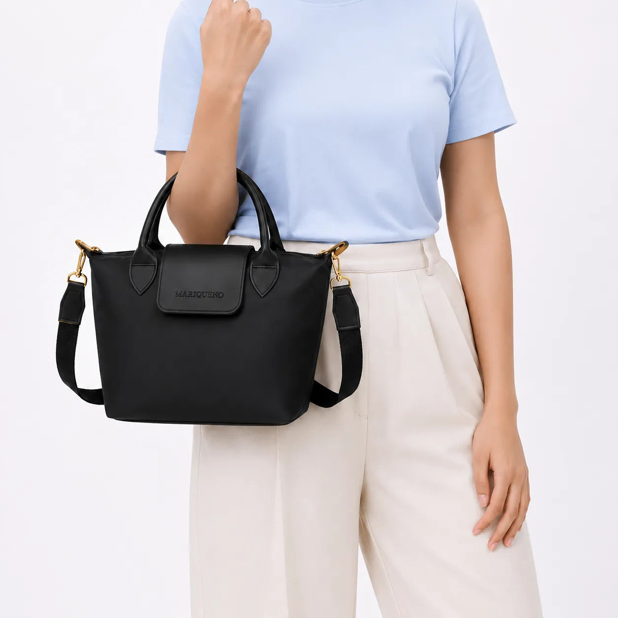 Person wearing a brown coat holding a black handbag on a white background
#color_black