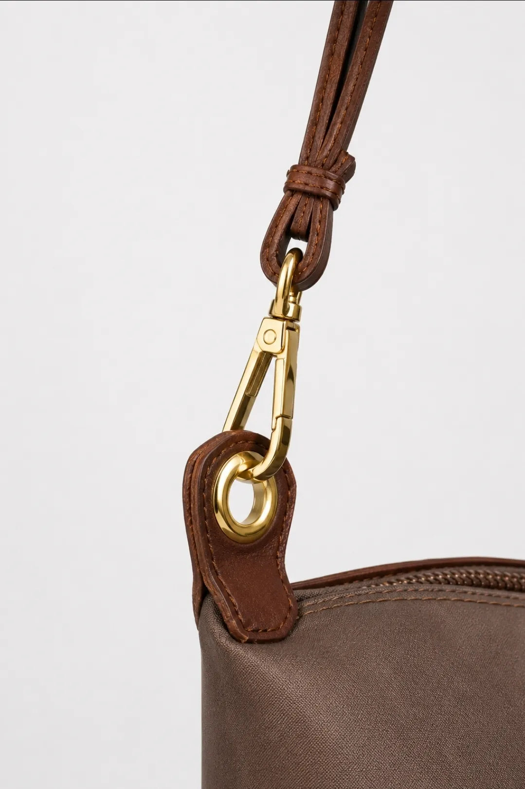 Brown bag with silver zipper and clasp on a white background, featuring Mariqueno branding.
#color_choco brown