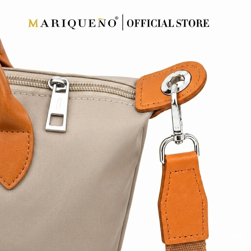 Close-up of a beige handbag with orange accents and a visible brand logo.
#color_taupe