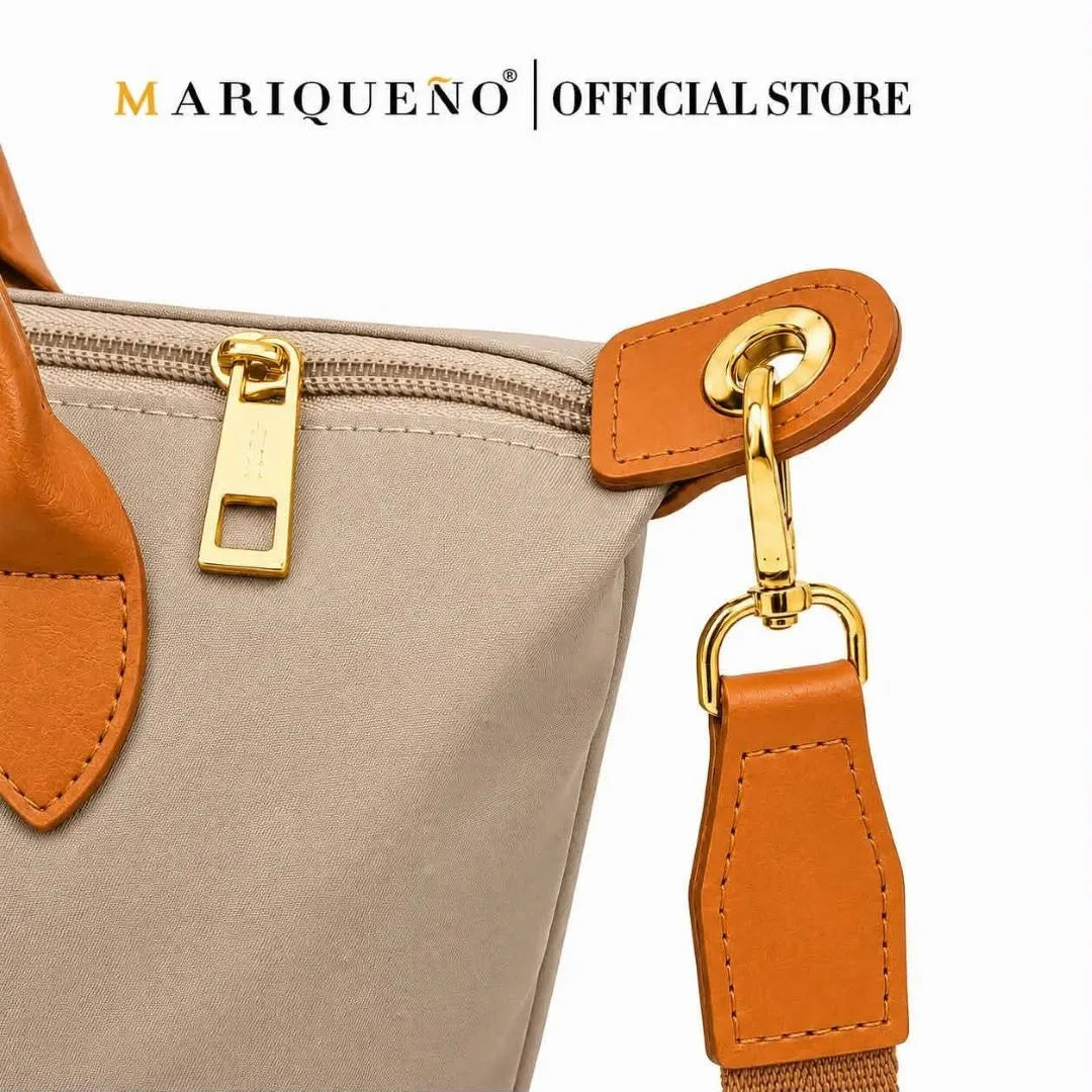 Close-up of a beige handbag with orange accents and a visible brand logo.
#color_taupe