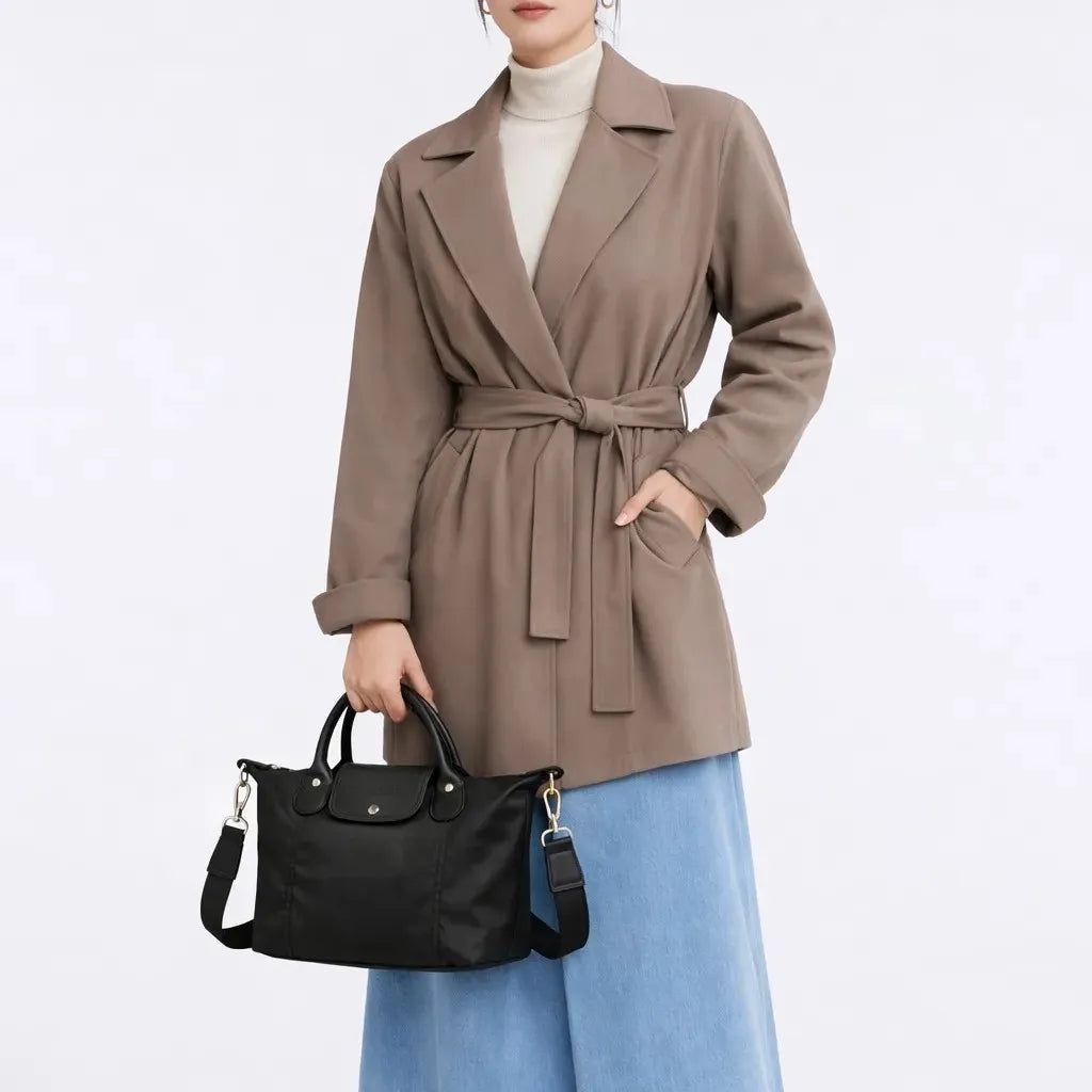 Person wearing a brown coat holding a black handbag on a white background
#color_black