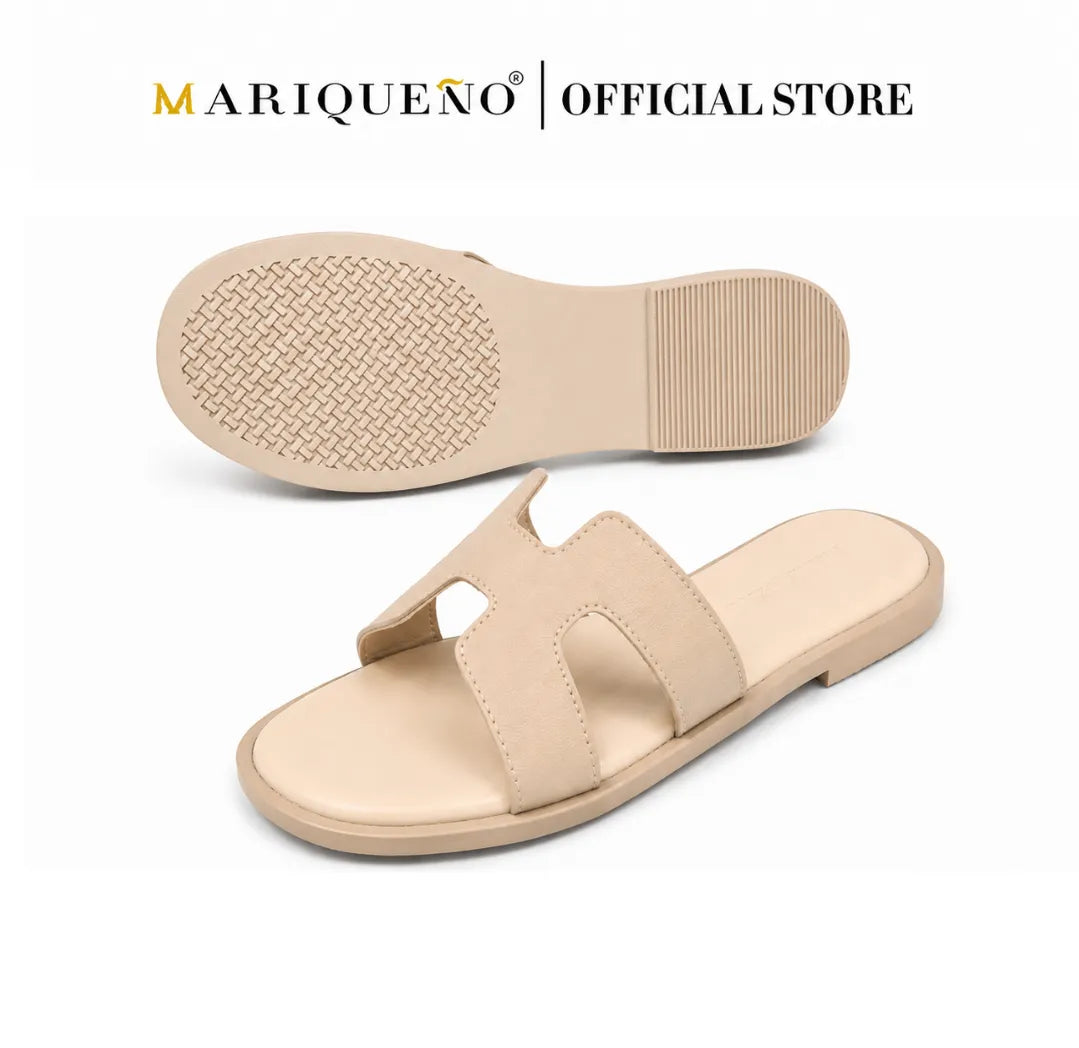 A pair of beige slide sandals shown on a white background, with one sandal displaying the top view and the other showing the sole. The brand name 'MARIQUEÑO | OFFICIAL STORE' is printed at the top.
#color_cream