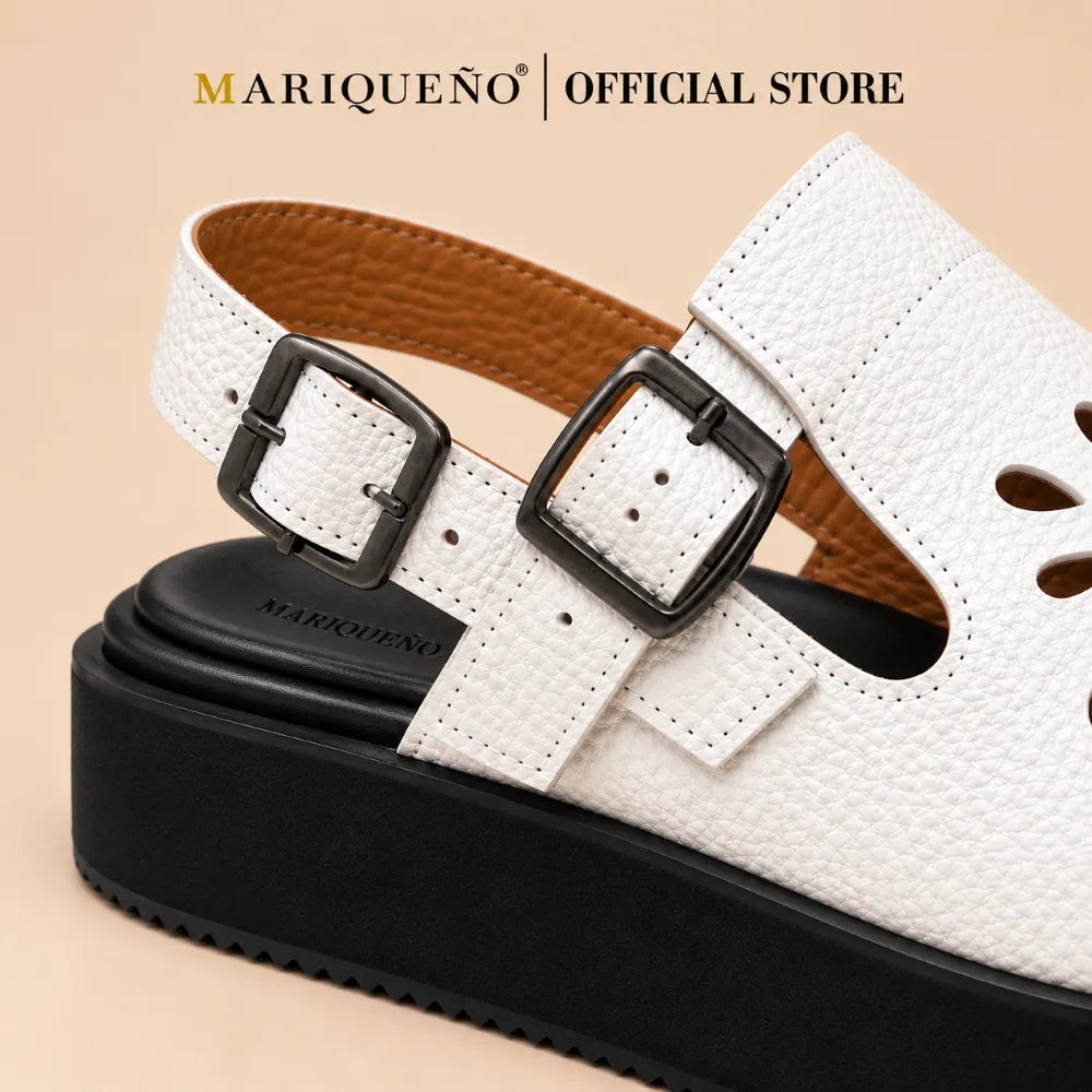Close-up of a white pebbled leather mule sandal with two dark metal buckles, a black platform sole, and a tan interior lining.
#color_white