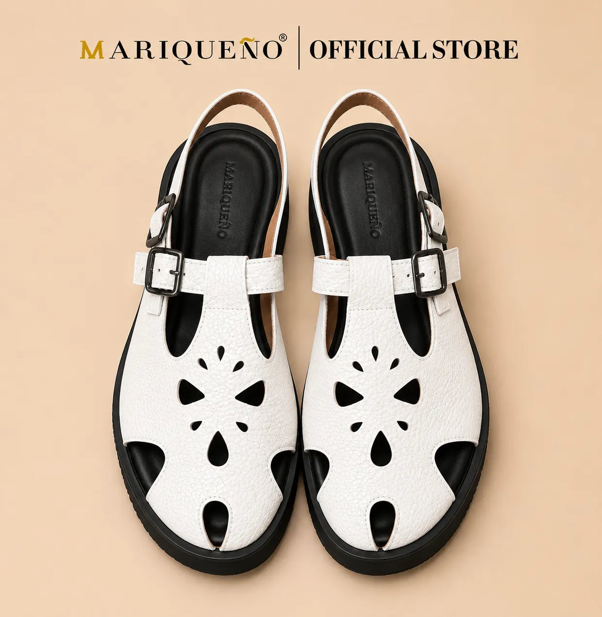 A pair of white leather clog sandals with black cutout floral details on the front, black soles, and silver buckle straps, shown from a top-down view on a white background with 'MARIQUENO | OFFICIAL STORE' text at the top.
#color_white