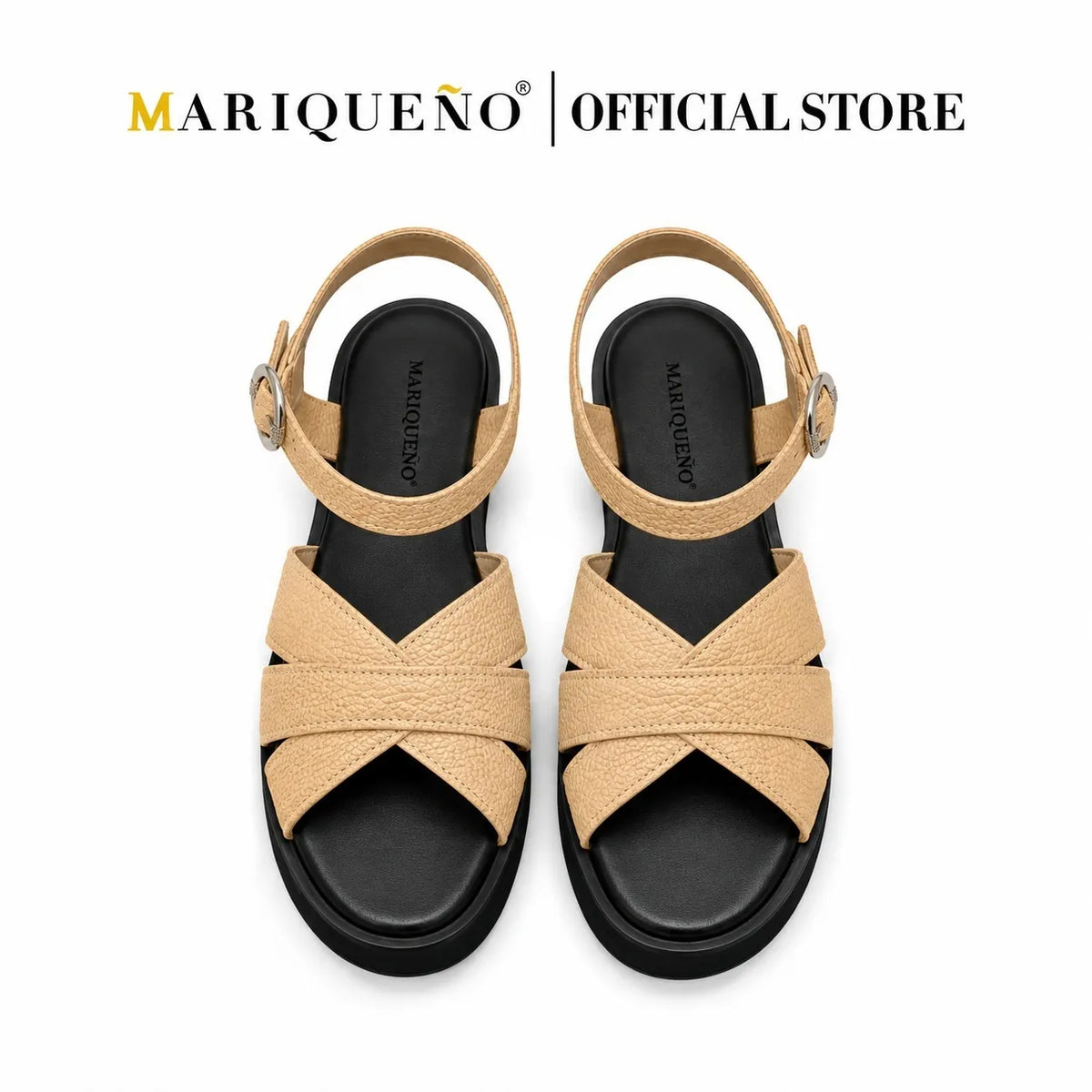 A pair of Mariqueno women's flat sandals in tan leather with a black sole and adjustable ankle straps, shown from a top-down view on a white background with the 'MARIQUEÑO | OFFICIAL STORE' logo at the top.
#color_beige