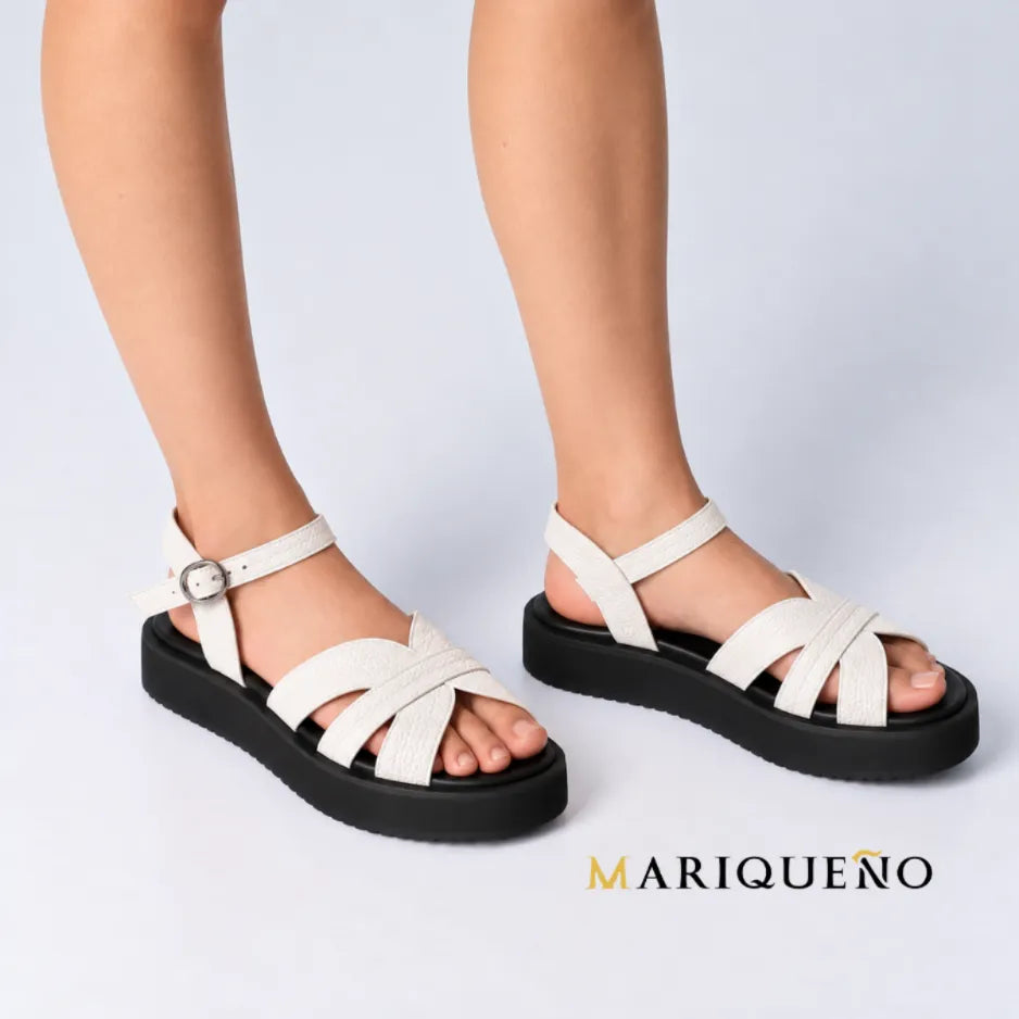 A person wearing off-white strappy platform sandals with black soles, shown from the knees down in a clean indoor setting.
#color_white