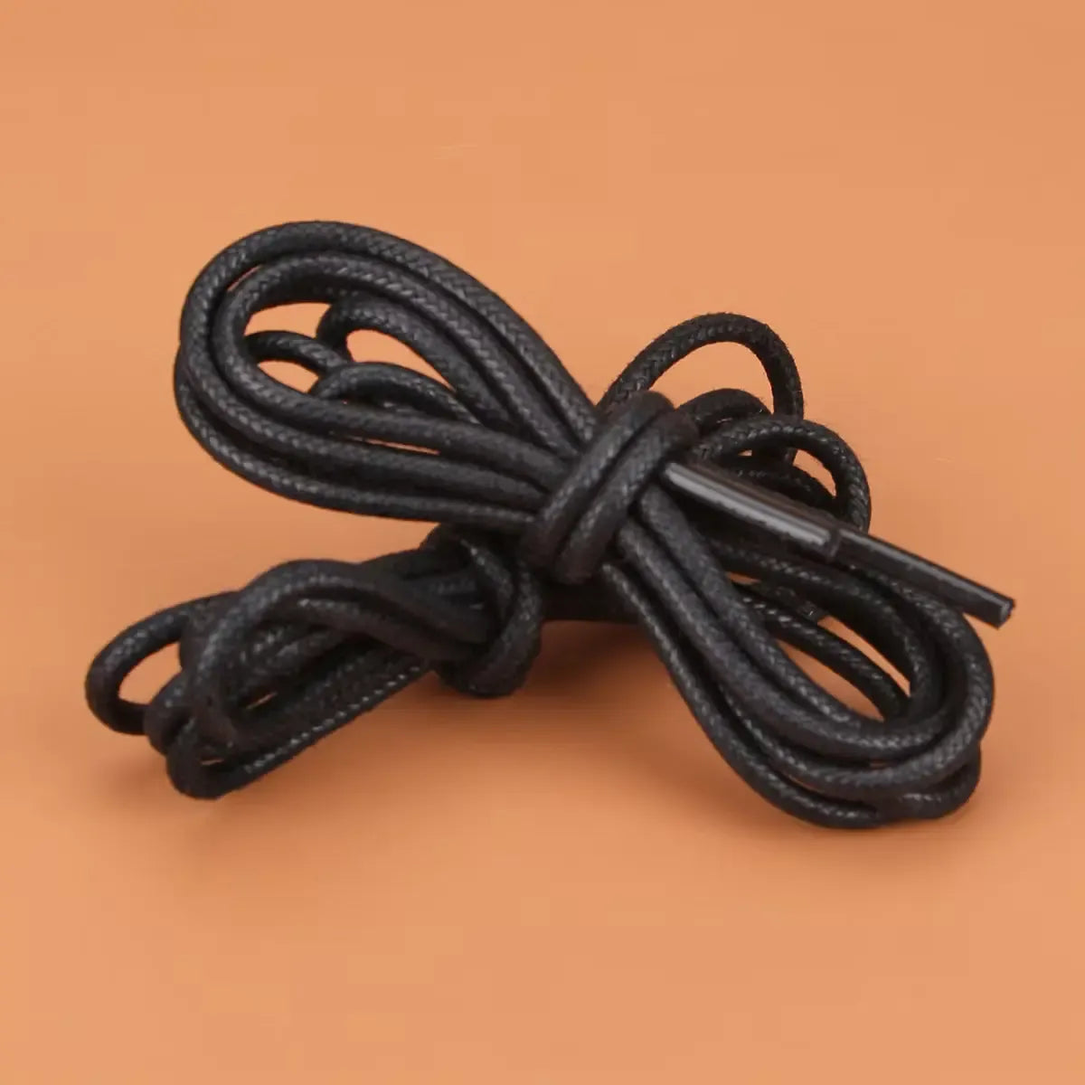 Coiled black shoelace on a brown background
#color_black