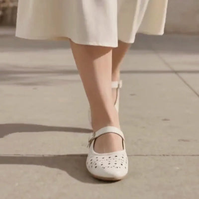 A woman wearing white mary jane flats
#color_white