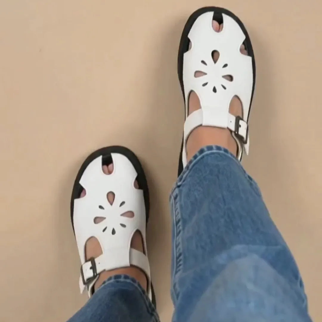 A woman wearing a pair of jeans and white comfort sandals
#color_white